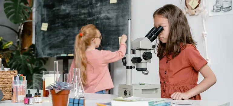 a girl looking through a microscope
