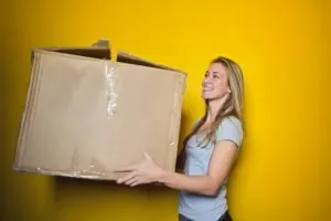a blonde girl holding a box