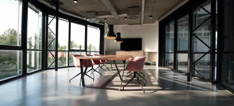 A spacious office with big windows and a large table and chair in the center of it