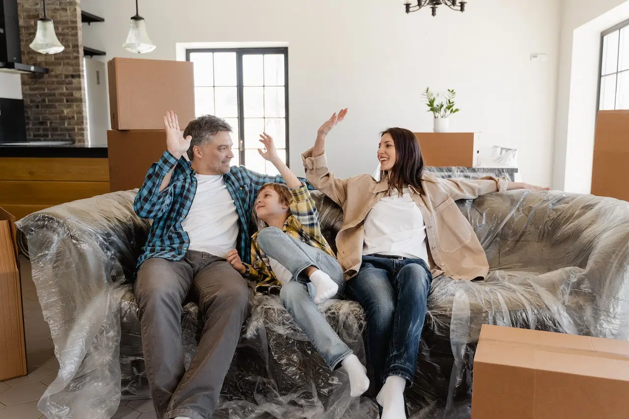 A family sitting on a couch after moving in
